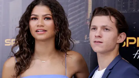Getty Images A much younger-looking Tom Holland and Zendaya together promoting Spider-Man: Homecoming in 2017. They are both wearing different shades of purple and she has on big hooped earrings