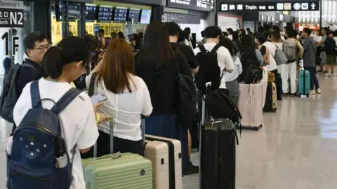 Reuters People stranded due to heavy rain crowd Narita International Airport