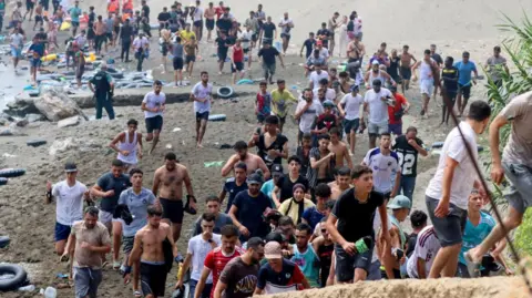 EPA/Shutterstock Migrants reach Spanish territory after swimming from Morocco to Ceuta, a Spanish enclave in North Africa, 30 July 2026.