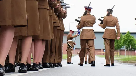 Getty Images A stock image shows the feet of junior soldiers lining up with guns as they prepare to march ahead of their graduation parade at the Army Foundation College in 2015.