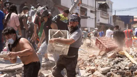 Reuters Residents dig through the debris of a collapsed building after an earthquake, in Cali, Colombia