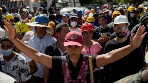 Reuters A woman gestures as people search for survivors at the site of a collapsed building, in the aftermath of an earthquake, in Cali, Colombia, August 11, 2026. 