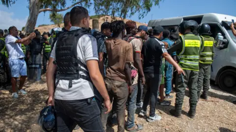 EPA/Shutterstock Moroccan security forces arrest migrants near Castillejos, Morocco