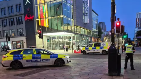 Police vehicles and officers outside the St Enoch Centre in Glasgow at night