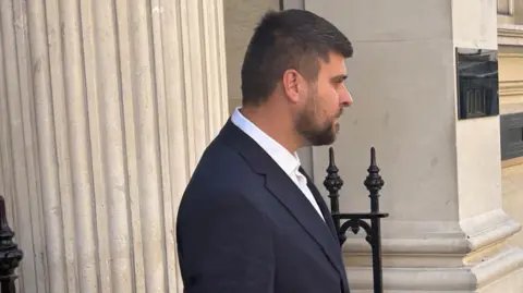 PA Media Joseph Gibson wearing a dark suit and white shirt leaves court.