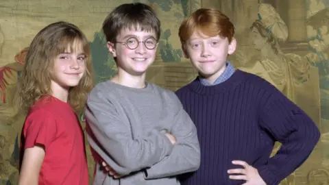 Getty Images The young Emma Watson, Daniel Radcliffe and Rupert Grint standing and posing together and smiling