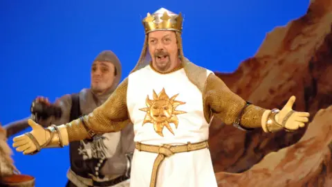 Getty Images Tim Curry in costume on stage in Spamalot