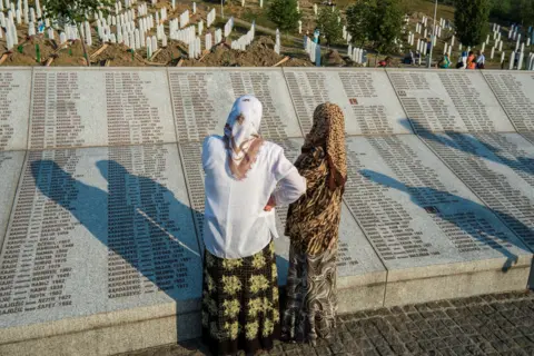 Getty Images Srebrenica-Potocari Memorial and Cemetery, Muslim women read names of victims of the July 1995 Srebrenica massacre, carried out by Bosnian Serb forces led by then General Ratko Mladic, photo taken in 2012