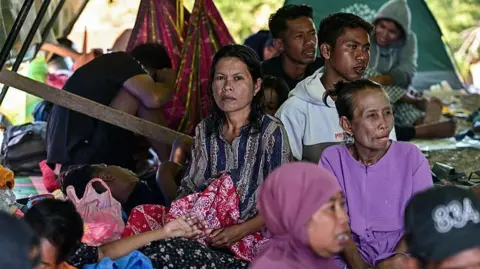 Getty Images Villagers rest in a tent in an open field in East Nusa Tenggara