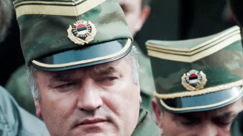 Reuters Bosnian Serb General Ratko Mladic leaves a meeting at the airport in Sarajevo, Bosnia and Herzegovina April 13, 1993. He is wearing a green and gold military peaked cap. 