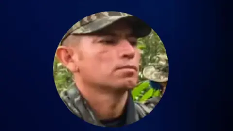 Twitter/@ABDELAESPRIELLA A screengrab from a video shared by Colombian President Abelardo de la Espriella shows a photo of Hernando Forero Mosquera, aka "El Ruso", accused of being a leader of a dissident Farc rebel faction. He is wearing a cap in camouflage colours and a shirt, also in camouflage colours. 