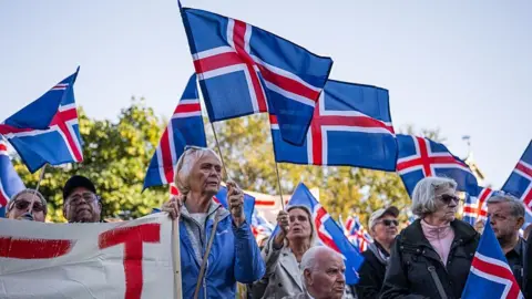 AFP via Getty Images Supporters of the 'No' campaign wave Icelandic flags during a rally against reopening Iceland's European Union accession negotiations in Reykjavik, Iceland, on August 27, 2026
