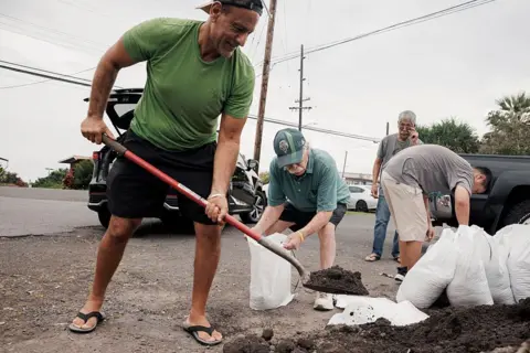 Getty Images Captain Hook, Hawaii residents prepare stuff bags with sand in preparation of Tropical Storm Lala on Friday