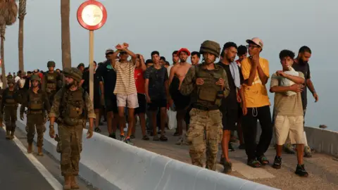 Reuters Members of the military escort migrants in Ceuta, Spain, following recent mass crossings of migrants on foot and by sea from Morocco into Spanish territory.
