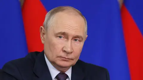 AFP via Getty Images Putin looking at a distance, wearing a dark coloured suit