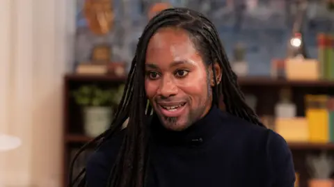 ITV/Shutterstock Jason Arday pictured during a TV interview in March 2023. He wears a black turtle-neck top.