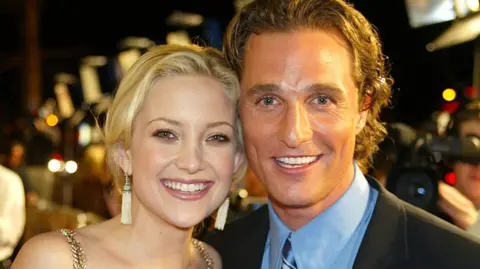 Getty Images Kate Hudson and Matthew McConaughey standing together and smiling in formal dress, with red carpet activity behind them