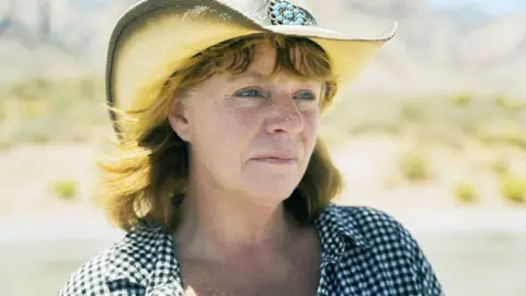BBC Holly Ratchford wears a straw cowboy hat while standing in the desert in an undisclosed location in the west of the United States.
