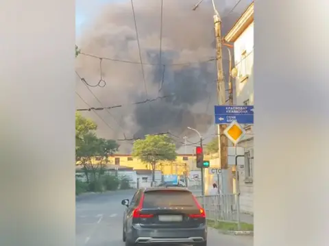 Volodymyr Zelensky/Telegram A plume of smoke rising over Novorossiysk