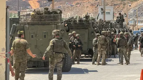 EPA/Shutterstock Spanish military personnel at the Tarajal border in Ceuta, Spain