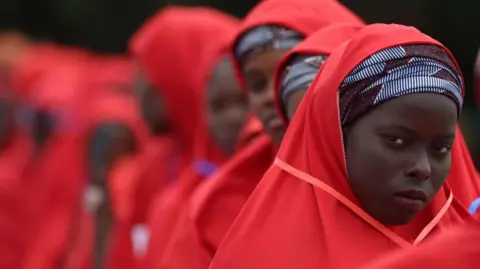 Getty Images Brides wearing red hijabs from the 2023 Kano mass wedding in Nigeria