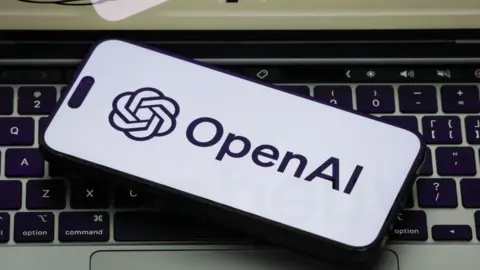 Getty Images The OpenAI logo on a white phone backgorund, the phone is on a laptop keyboard