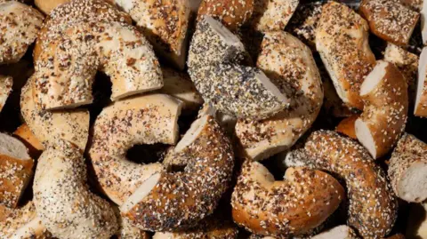 Getty Images Everything bagels baked with a mix of toppings including garlic flakes, onion flakes, poppy seeds, sesame seeds and salt