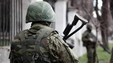 Getty Images An unidentifiable Russian soldier stands with his back to the camera