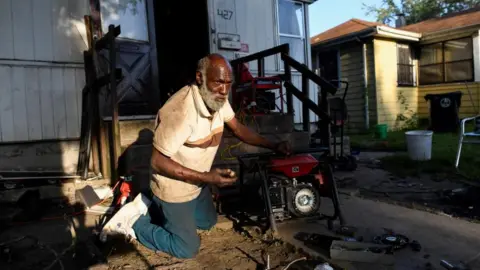 Reuters Anthony Lewis repairs a generator at his home while coping without electricity, as thousands of residents remain without power more than a week after severe storms struck Gary, Indiana.