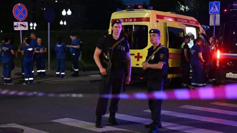 Getty Images Armed Moscow police stand guard in front of an ambulance near the scene of an explosion near the centre of the city.