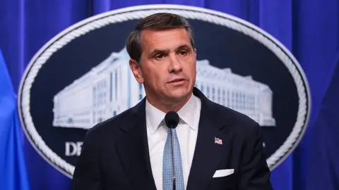 Getty Images Todd Blanche, wearing a suit and light blue tie, speaks during a news conference at the Robert F. Kennedy Department of Justice building.
