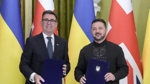 EPA Ukrainian President Volodymyr Zelensky (R) and Prime Minister of Britain Andy Burnham (L) pose as they attend a signing documents ceremony during their meeting at the Presidential office in Kyiv, Ukraine, 24 August 2026, amid the ongoing Russian invasion. 