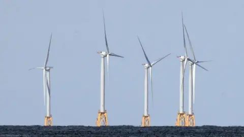 Getty Images Five wind turbines mounted on yellow metal structures embedded into the sea bed at the Block Island Wind Farm off the coast of Block Island, RI.