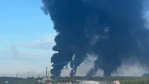 Telegram/Crimeanwind Huge plumes of smoke seen rising in the skies from the site where the Slavneft-Yanos oil is located. 