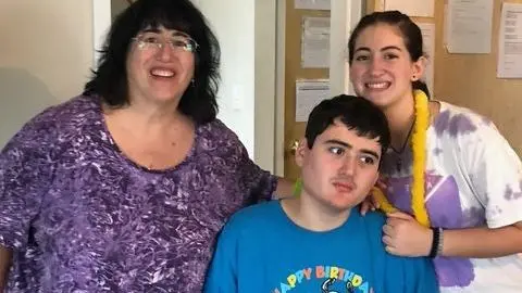 Linda Mancuso Linda Mancuso, wearing a purple top, glasses and dark hair falling to her shoulders, stands next to her 23-year-old son, Michael, who needs 24/7 care; he wears a "Happy Birthday" blue shirt and stares off to the side; her daughter stands to the other side of Michael, smiling as she rests a hand on his shoulder