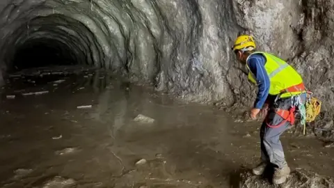 Reuters A rescuer works at the entrance of a tunnel at Chilime Hydropower Plant as rescue operations continue for people trapped inside following deadly flash floods and a mudslide, in Rasuwa, Nepal.