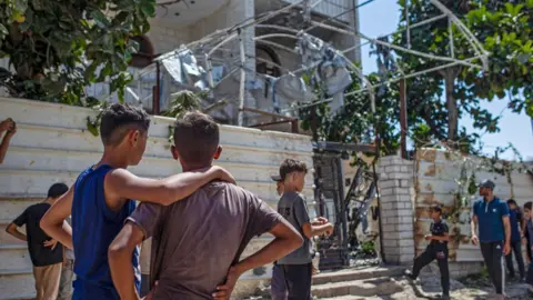 Reuters Boys look at a building damaged by an Israeli strike in western Gaza City (1 September 2026)