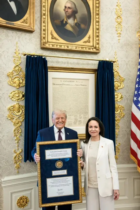 EPA María Corina Machado and President Trump hold the Nobel in the White House
