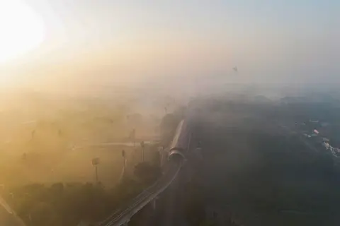 Getty Images An aerial shot of a train line running through fields and shrouded in smoke