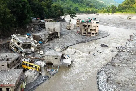 AFP A Muddy Trishuli River surging past collapsing houses after flash floods in Nuwakot, Nepal