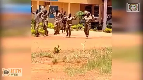 APTN A screengrab from Niger's state television showing a grainy image of people in army uniforms holding their hands up as they walk along a dusty road.