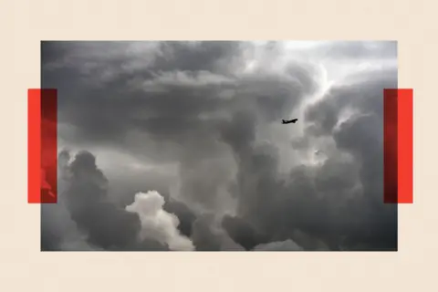 AFP via Getty Images A distant shot of a plane flying through the clouds