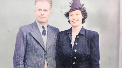 Sweeney family Ted and Maureen Sweeney in smart suits, smiling in a photo from 1946