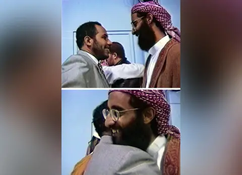 SDNY A composite of two stills from video footage showing two men, one in a suit and the other in Arabic dress. The top image shows the men about to embrace. The bottom shows the moment they do.