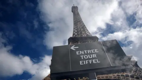 Reuters The Eiffel Tower is seen from the base of the monument with clouds and blue skies around it