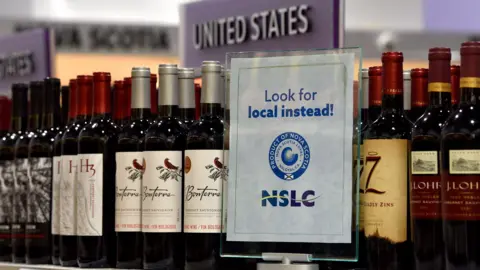 Reuters A "Look for local instead" sign displayed on a shelf with wine at a Canadian liquor shop.