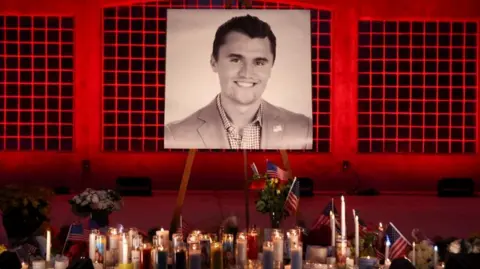 Reuters Candles and flowers are placed near an image of Charlie Kirk, during a vigil at Orem City Center Park, after U.S. right-wing activist and commentator, Charlie Kirk.