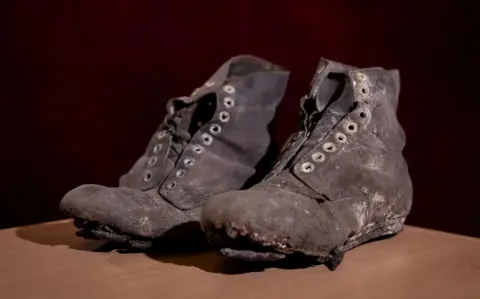 PA Media A pair of battered black hobnail boots
