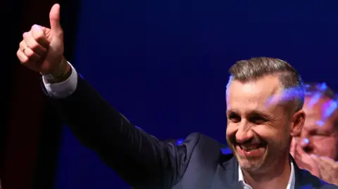 Reuters Ulrich Siegmund, leader of the AfD in the state, raises a thumbs up at the election party.