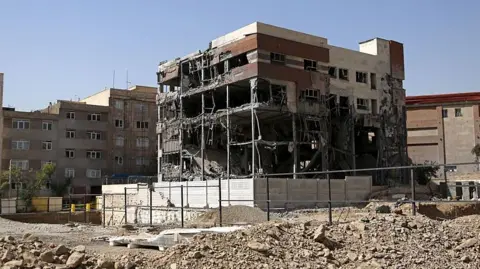 Anadolu via Getty Images General view of a five-storey building in Tehran. The building has been shelled-out by a reported missile attack, the outer brickwork is no longer visible and instead the building is hollowed out but is still standing. It is surrounded by rubble